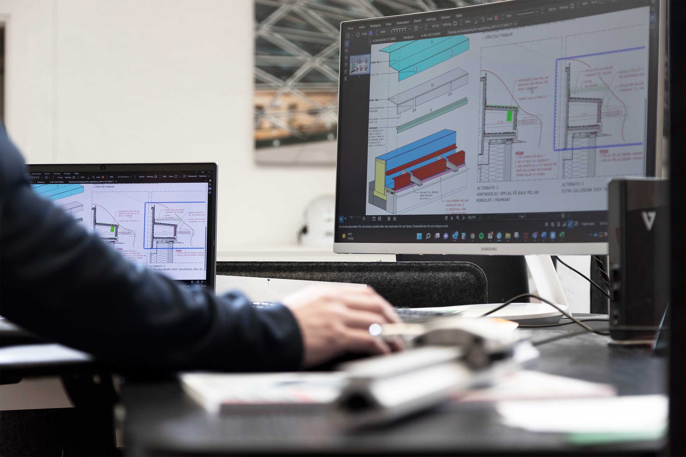 Två datorskärmar med konstruktionsprogram igång