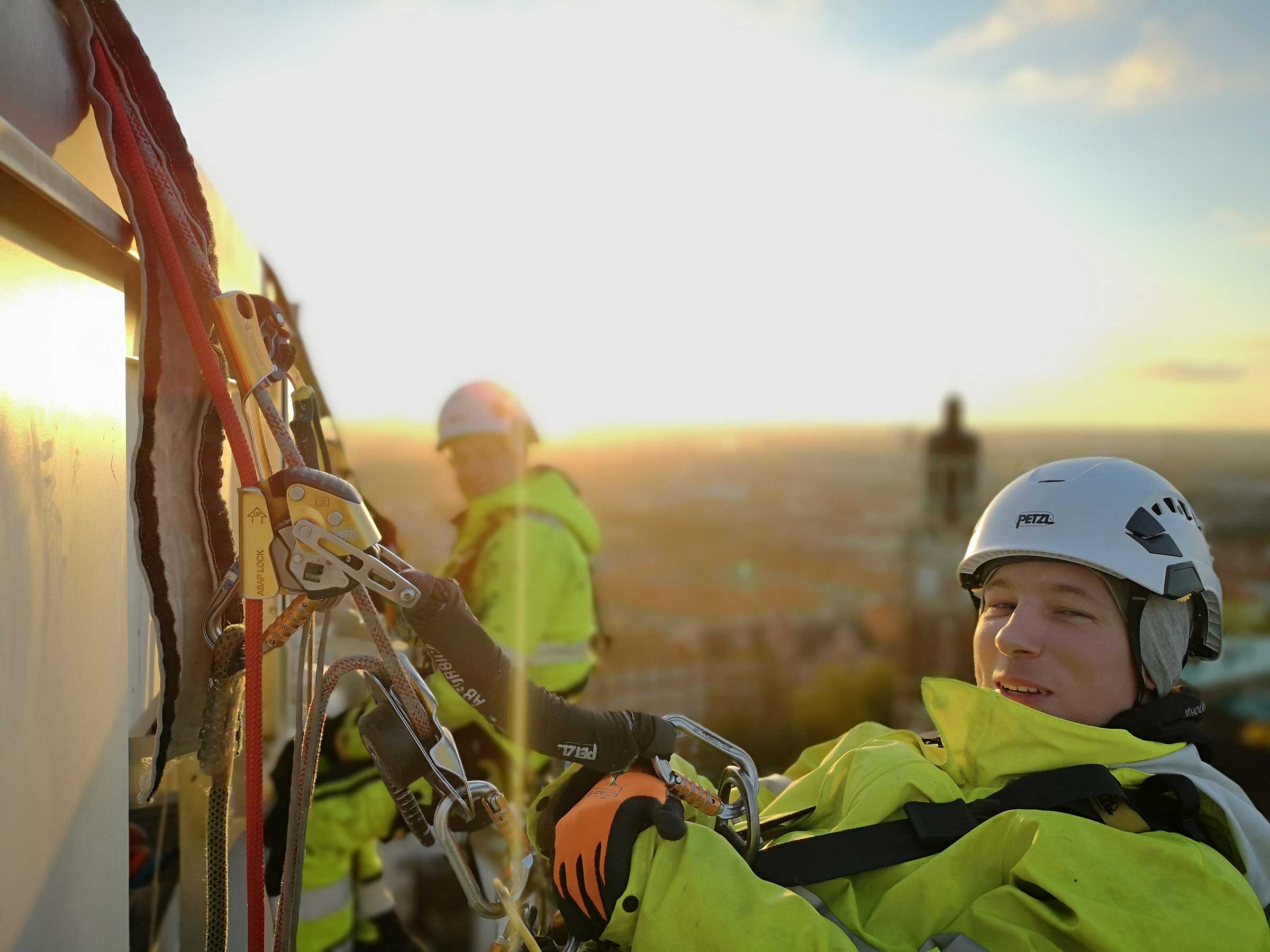 två kollegor hängandes i sele vid solnedgång