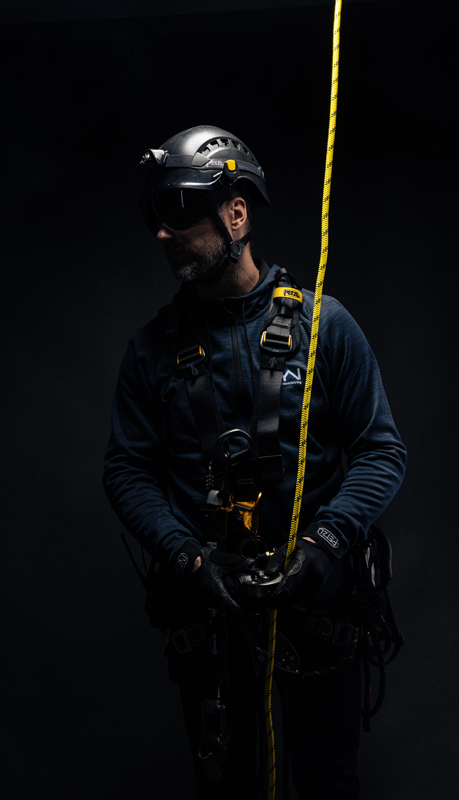 arbetare poserar klädd i sele och säkerhetslina kopplad